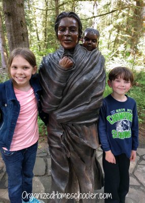 My children standing with a statue of Sacagawea during the field trip portion of our Lewis and Clark unit study