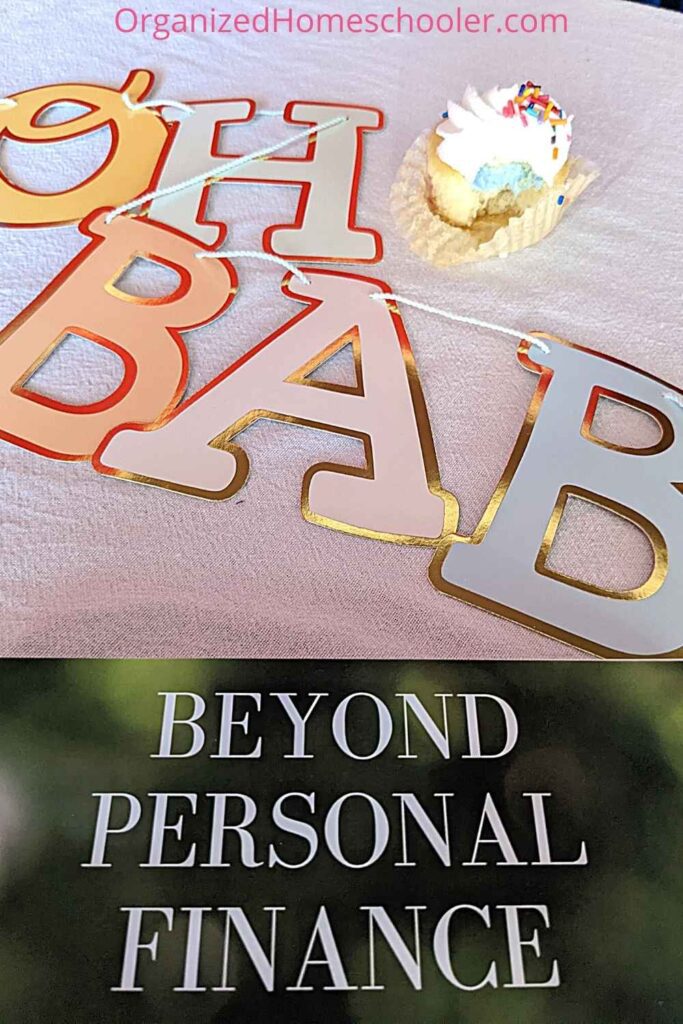 Beyond Personal Finance curriculum book next to the set up for the first baby game